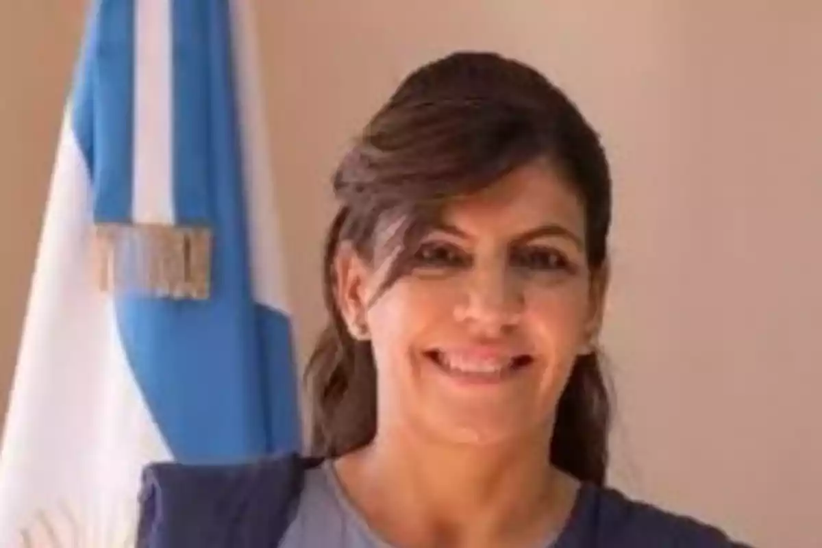 Mujer sonriendo con una bandera de Argentina al fondo