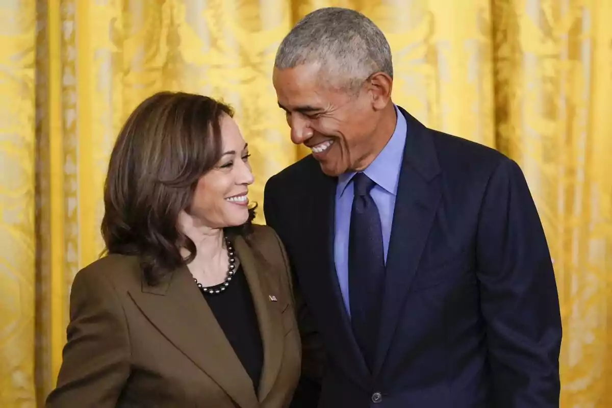 Dos personas elegantemente vestidas se miran y sonríen en un ambiente formal con cortinas doradas de fondo Dos personas elegantemente vestidas se miran y sonríen en un ambiente formal con cortinas doradas de fondo