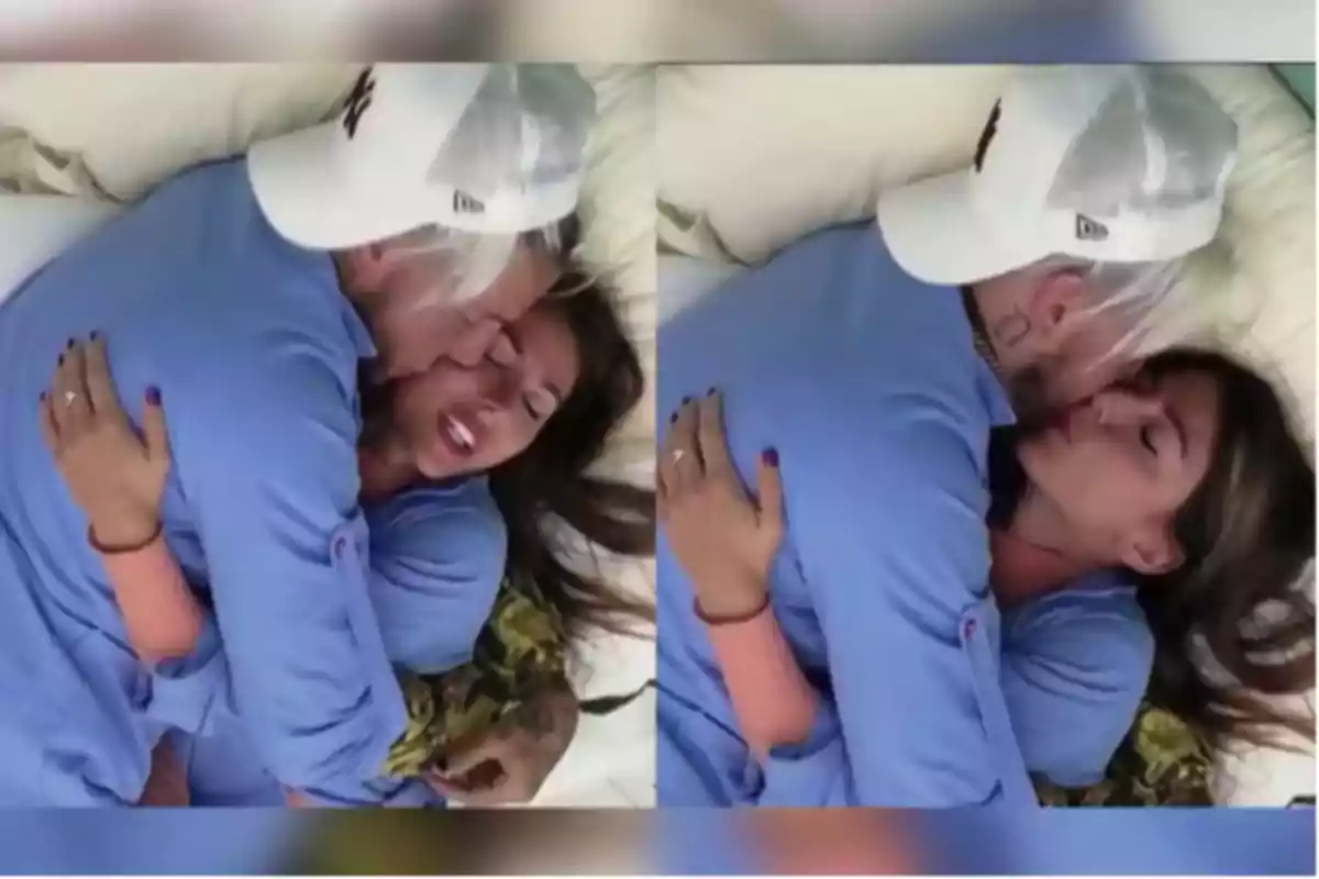 Pareja acostada abrazándose y besándose en una cama, ambos vestidos con ropa azul y el hombre lleva una gorra blanca Pareja acostada abrazándose y besándose en una cama, ambos vestidos con ropa azul y el hombre lleva una gorra blanca