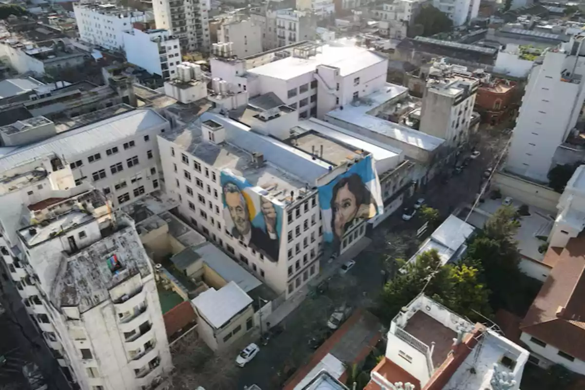 Vista aérea de un barrio urbano con murales grandes de rostros en la fachada de un edificio blanco Vista aérea de un barrio urbano con murales grandes de rostros en la fachada de un edificio blanco