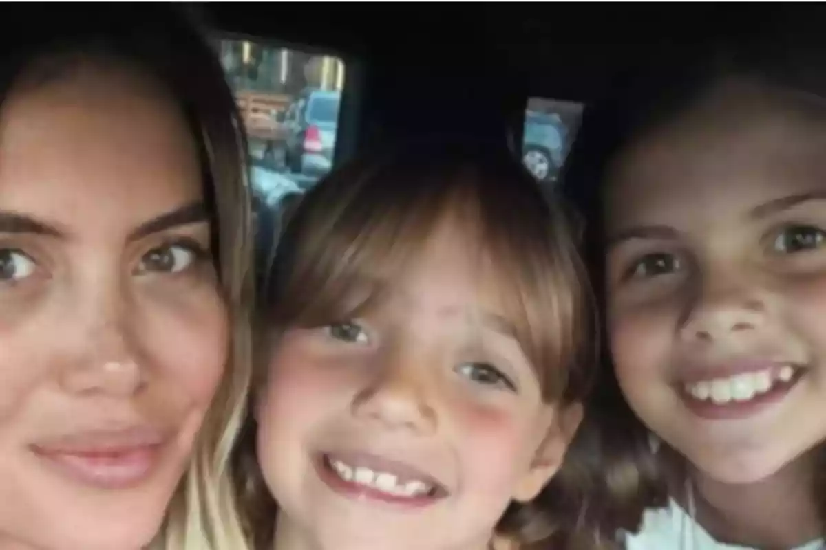 Three people smile while posing for a selfie inside a car. Three people smile while posing for a selfie inside a car.