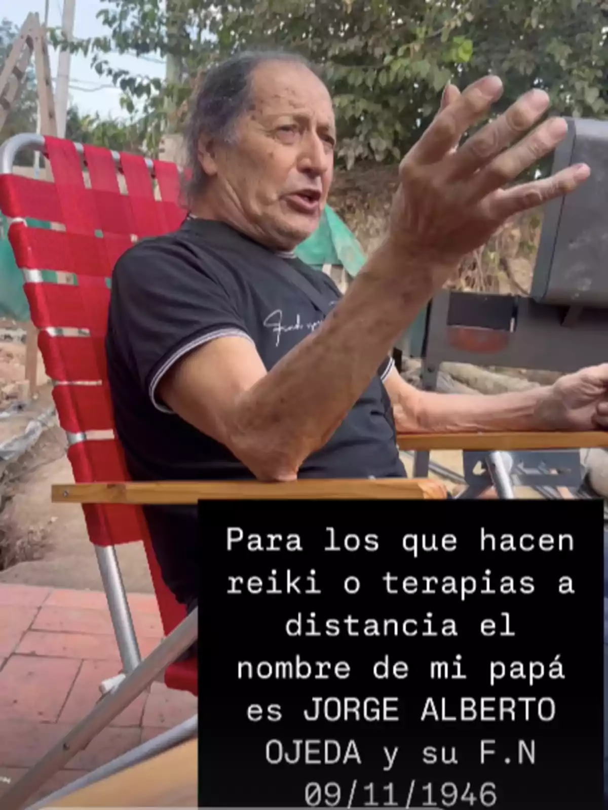 Hombre mayor sentado en una silla roja al aire libre levantando una mano mientras viste una camiseta negra, con un texto en la parte inferior que solicita terapias a distancia para una persona llamada Jorge Alberto Ojeda y menciona una fecha de nacimiento 09/11/1946 Hombre mayor sentado en una silla roja al aire libre levantando una mano mientras viste una camiseta negra, con un texto en la parte inferior que solicita terapias a distancia para una persona llamada Jorge Alberto Ojeda y menciona una fecha de nacimiento 09/11/1946