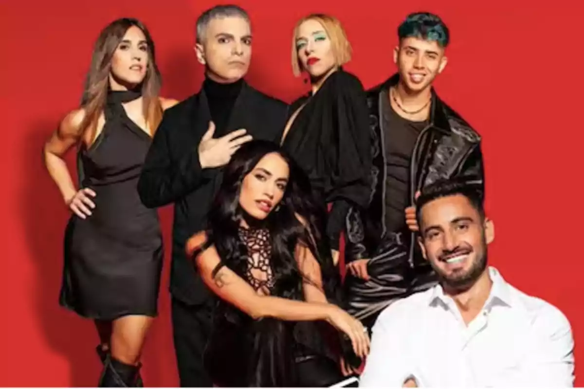 Seis personas posan frente a un fondo rojo, todas vestidas de manera elegante y moderna, algunas de pie y otras sentadas, mirando a la cámara.