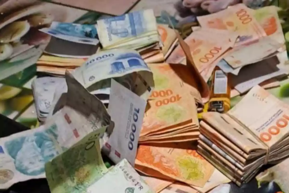 Several bundles of bills of different denominations and colors stacked on a table