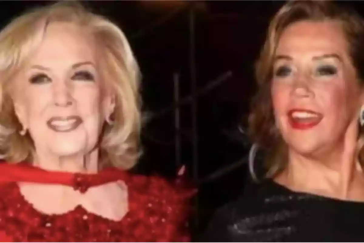 Dos mujeres sonrientes posan juntas en un evento elegante, una lleva un vestido rojo brillante y la otra un vestido negro