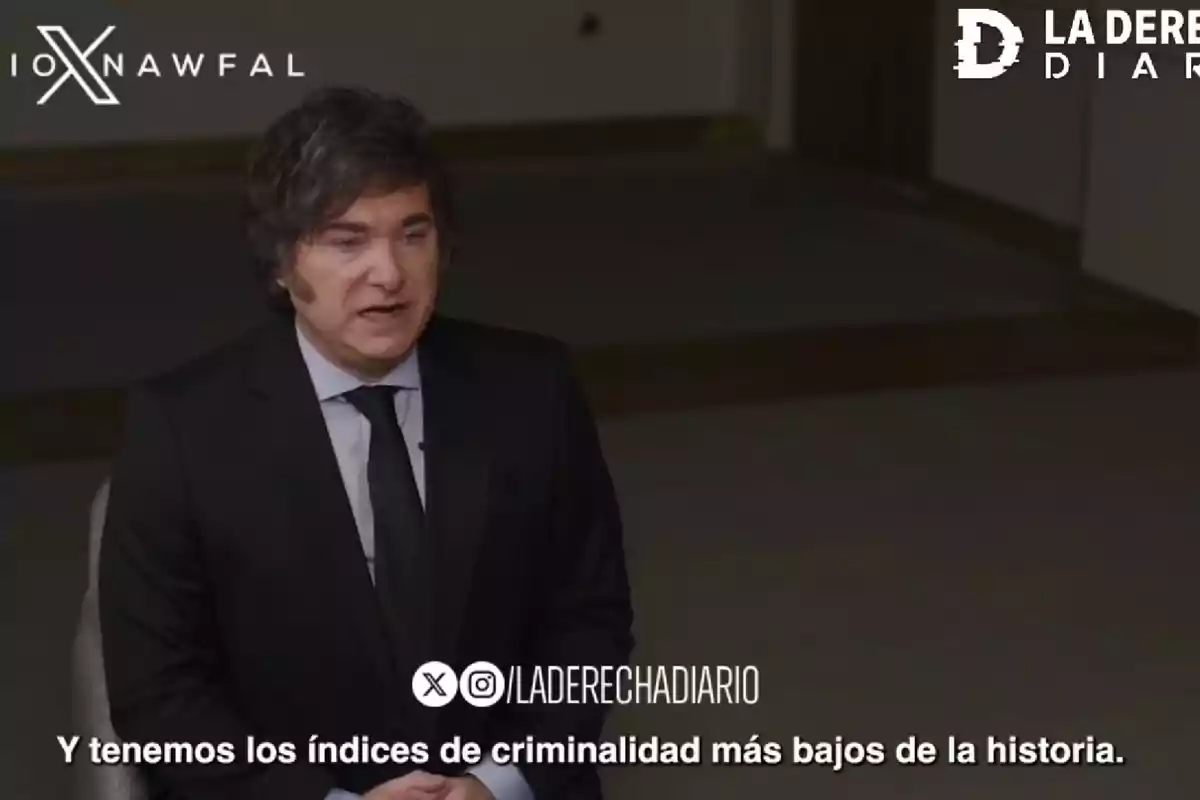 Hombre de cabello ondulado y traje oscuro hablando en una entrevista con subtítulo que dice Y tenemos los índices de criminalidad más bajos de la historia