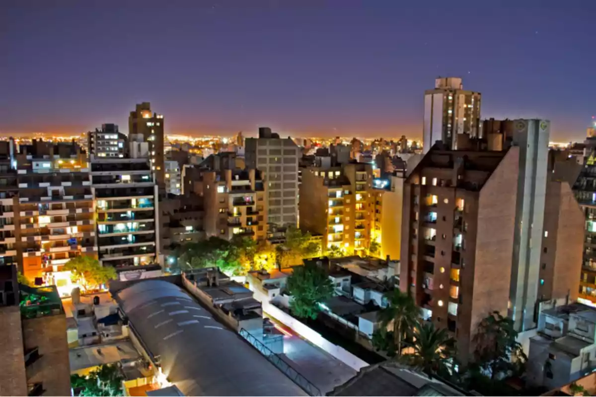Night view of a city with illuminated buildings and a clear sky