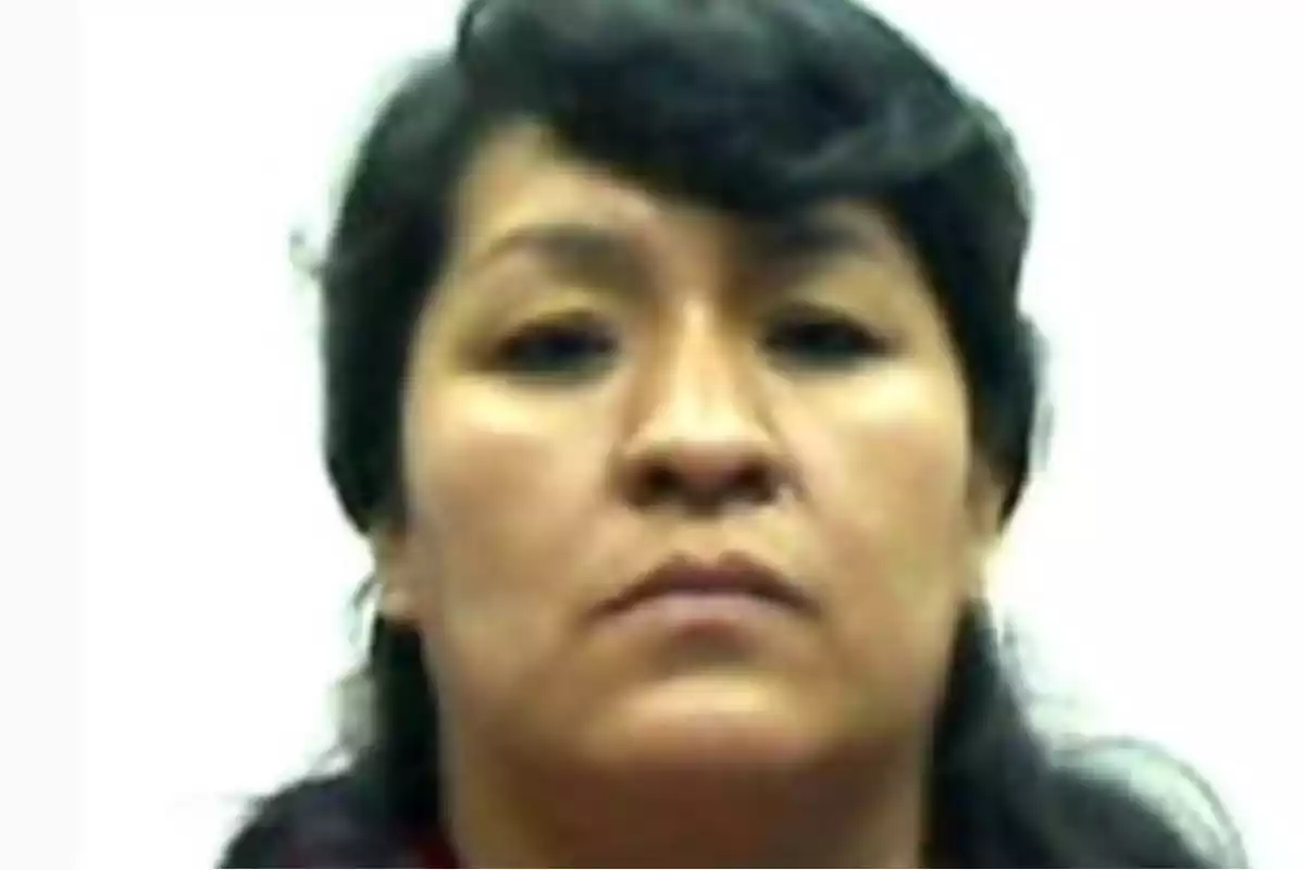 Retrato de una mujer de cabello oscuro con expresión seria y fondo blanco Retrato de una mujer de cabello oscuro con expresión seria y fondo blanco