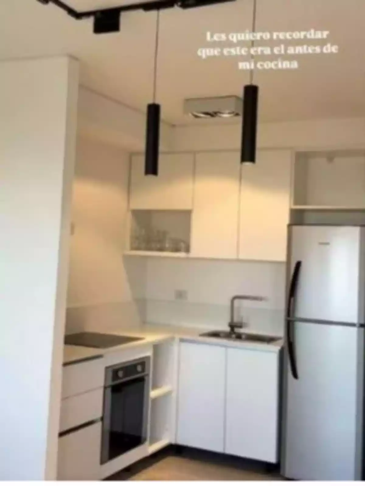 Cocina pequeña de estilo moderno con muebles blancos, estufa, horno, fregadero y refrigerador plateado Cocina pequeña de estilo moderno con muebles blancos, estufa, horno, fregadero y refrigerador plateado