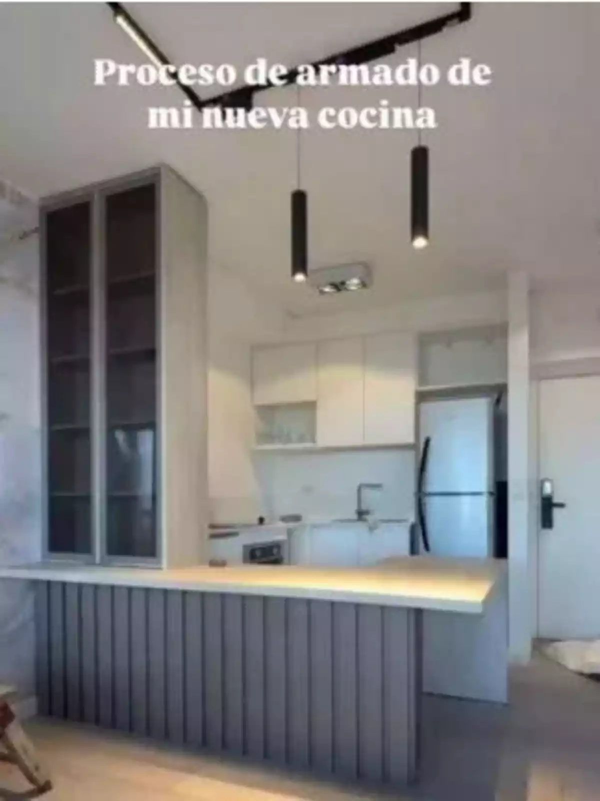 Cocina moderna en proceso de armado con muebles blancos, una isla central y electrodomésticos de acero inoxidable Cocina moderna en proceso de armado con muebles blancos, una isla central y electrodomésticos de acero inoxidable