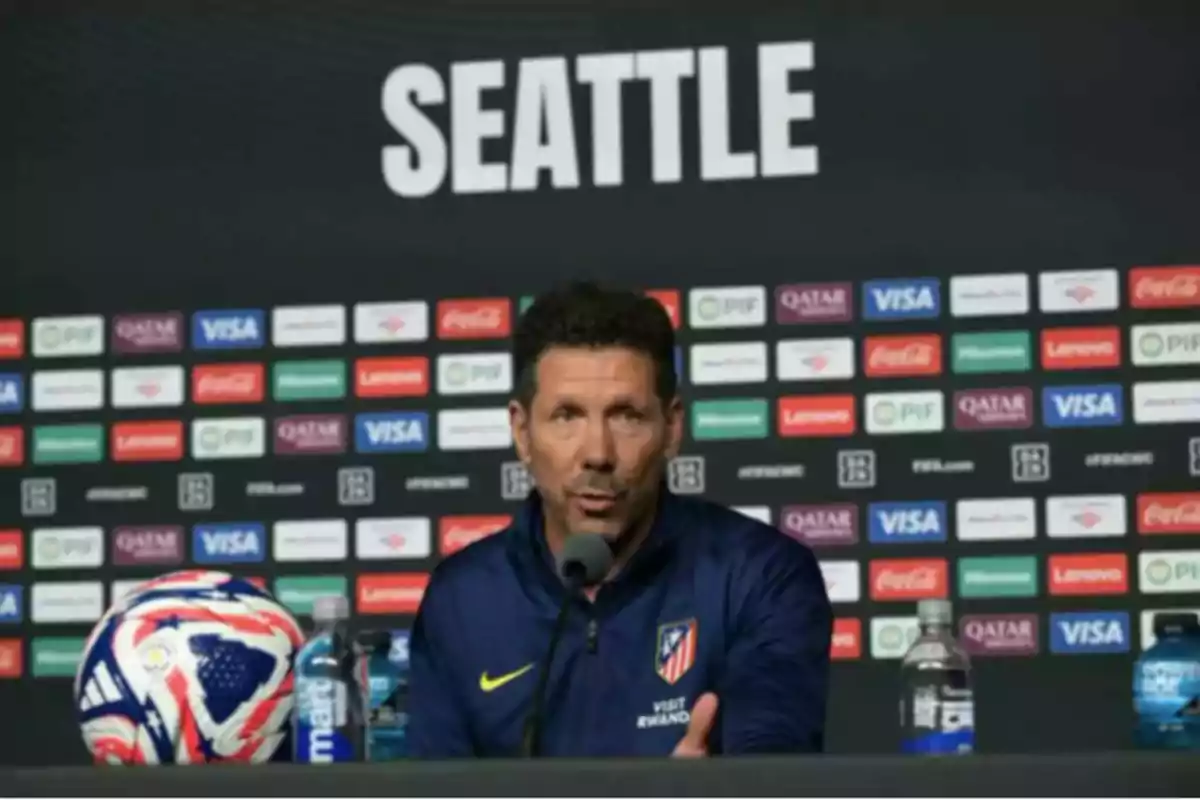 Atlético de Madrid coach at a press conference in Seattle with a ball and water bottles on the table Atlético de Madrid coach at a press conference in Seattle with a ball and water bottles on the table