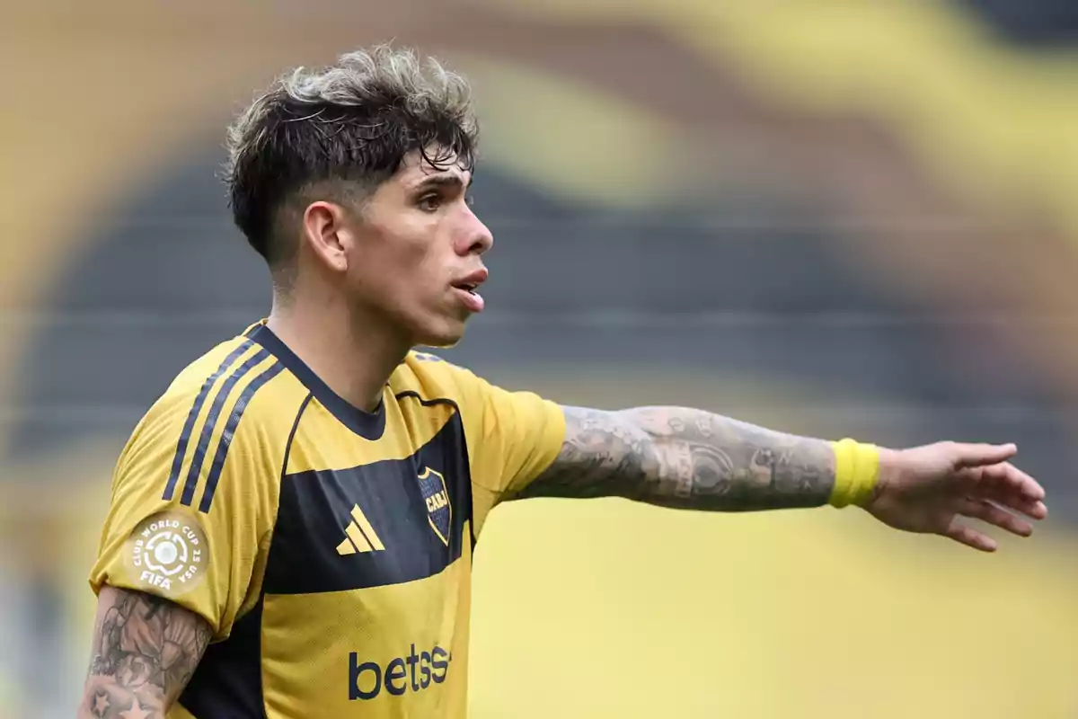 Futbolista con uniforme amarillo y negro señalando con el brazo extendido durante un partido Futbolista con uniforme amarillo y negro señalando con el brazo extendido durante un partido