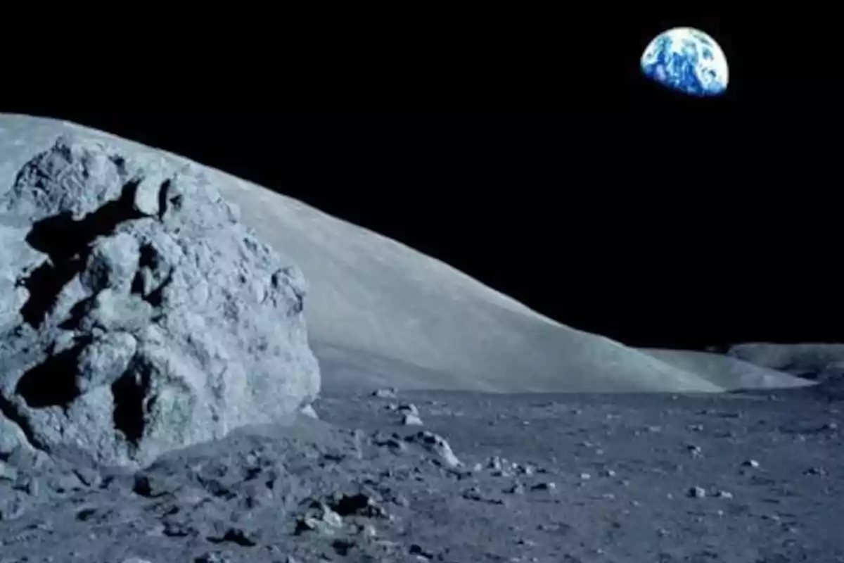 Rocky surface of the Moon with the Earth visible in the background against a black sky Rocky surface of the Moon with the Earth visible in the background against a black sky