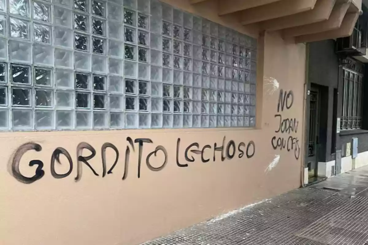 Pared de edificio con grafitis en letras negras que dicen gordito lechoso y no jodan con CFK Pared de edificio con grafitis en letras negras que dicen gordito lechoso y no jodan con CFK