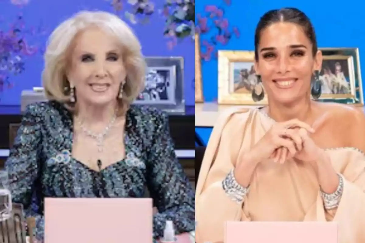 Dos mujeres sentadas en una mesa de televisión con fondo azul y decoraciones florales, ambas sonríen y llevan vestidos elegantes