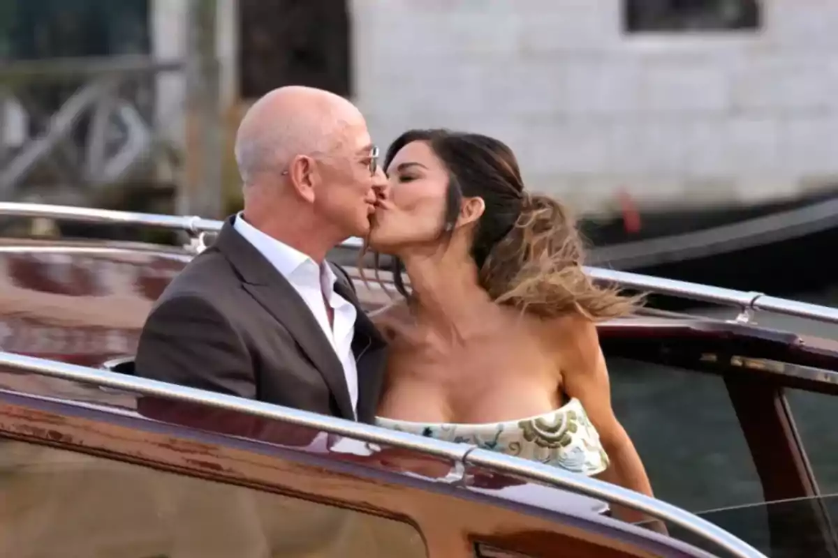 Pareja besándose mientras viajan en un bote elegante sobre el agua