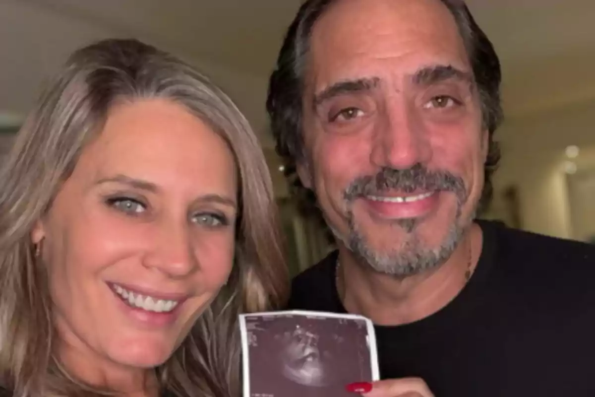 Smiling couple showing an ultrasound Smiling couple showing an ultrasound