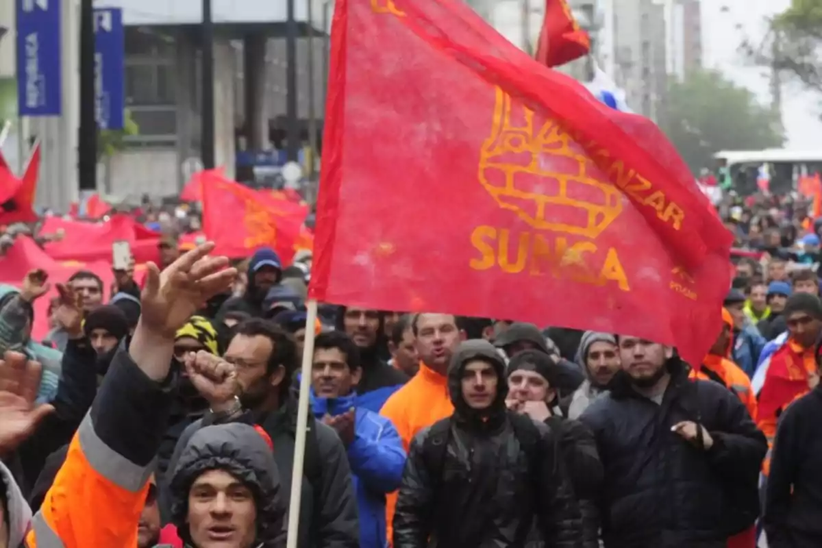 Workers' demonstration with red SUNCA union flags on a city street Workers' demonstration with red SUNCA union flags on a city street
