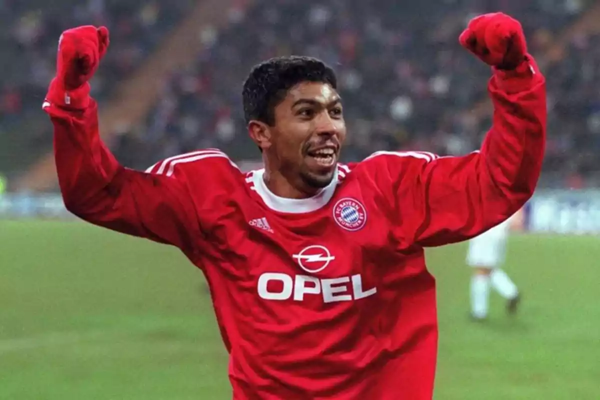 Futbolista celebrando un gol con el uniforme rojo del Bayern Múnich en un estadio Futbolista celebrando un gol con el uniforme rojo del Bayern Múnich en un estadio