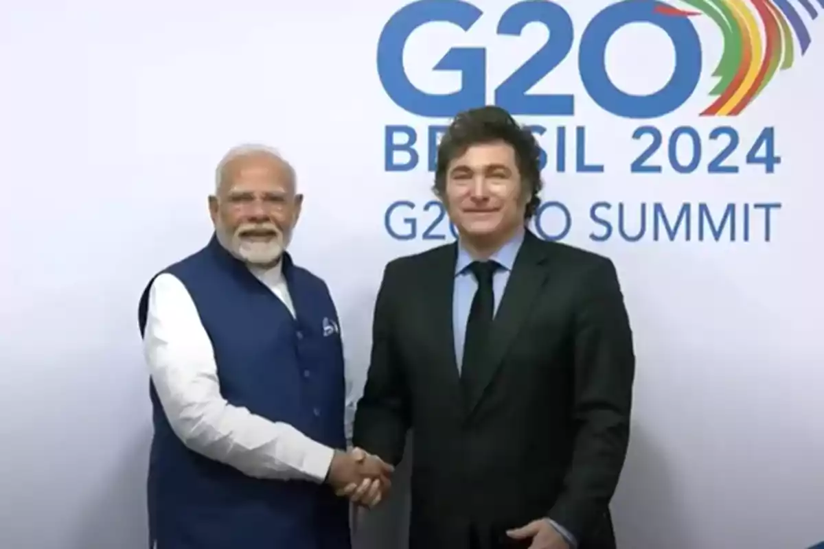 Two world leaders shake hands in front of a backdrop featuring the G20 Brazil 2024 summit logo. Two world leaders shake hands in front of a backdrop featuring the G20 Brazil 2024 summit logo.
