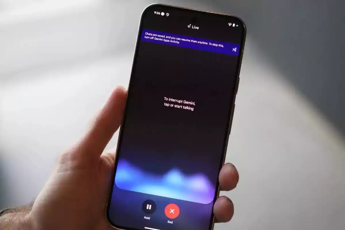 Persona sosteniendo un teléfono inteligente que muestra la interfaz de una aplicación de asistente virtual llamada Gemini Persona sosteniendo un teléfono inteligente que muestra la interfaz de una aplicación de asistente virtual llamada Gemini