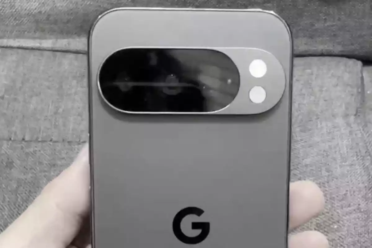 Persona sosteniendo un teléfono inteligente gris de Google con un módulo de cámara ovalado en la parte trasera