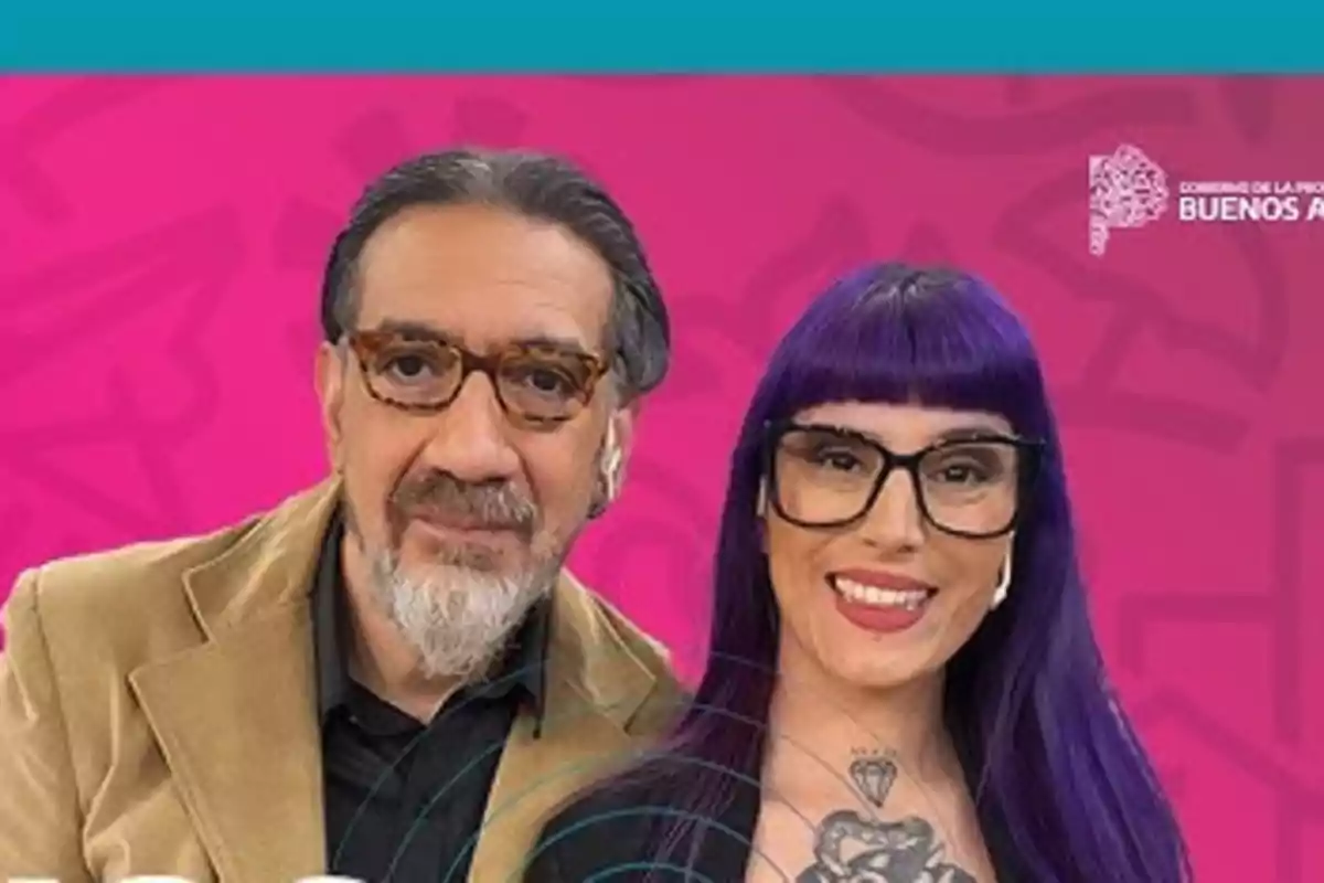Dos personas con gafas posan sonrientes frente a un fondo rosa con detalles gráficos y un logo en la esquina superior derecha