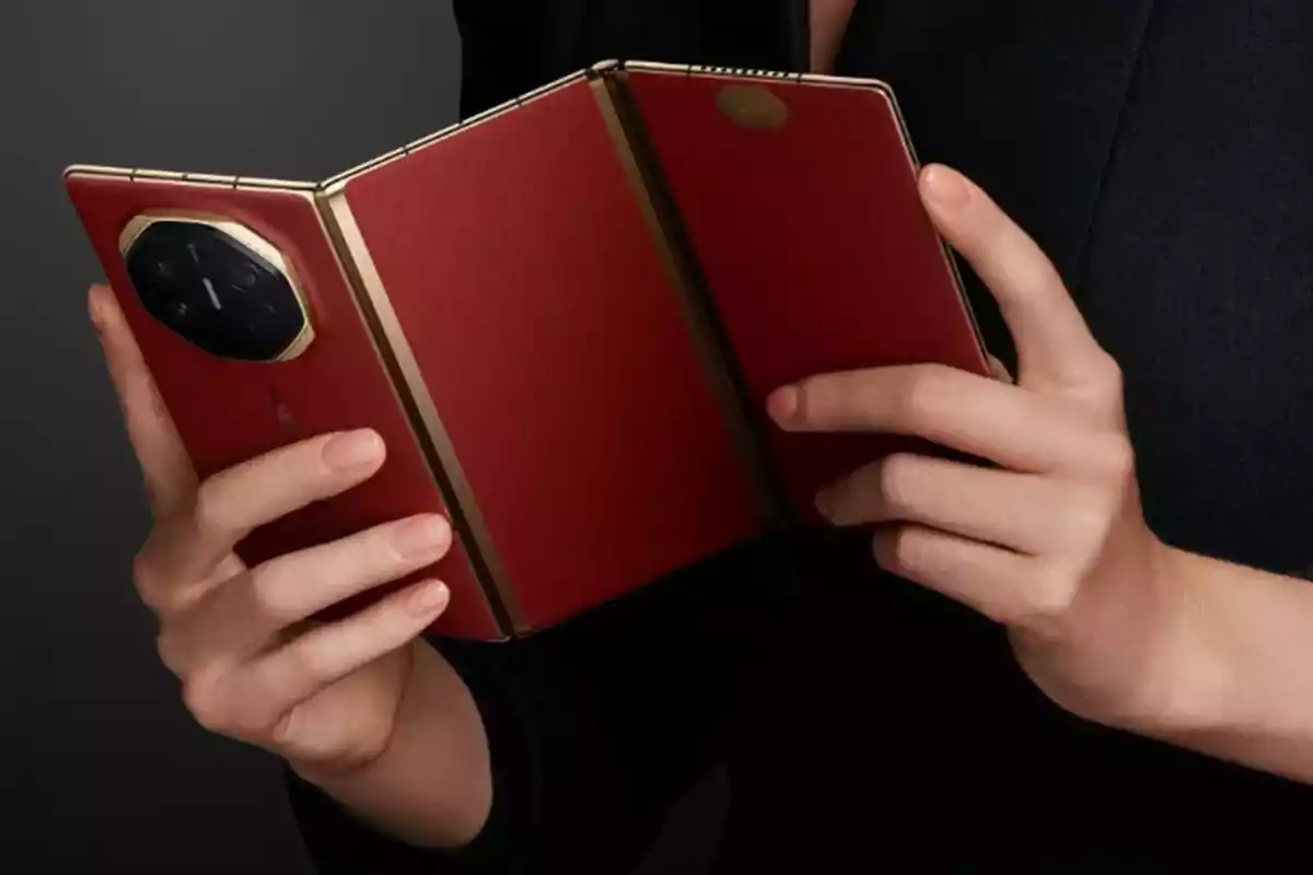 Persona sosteniendo un teléfono plegable de color rojo con detalles dorados