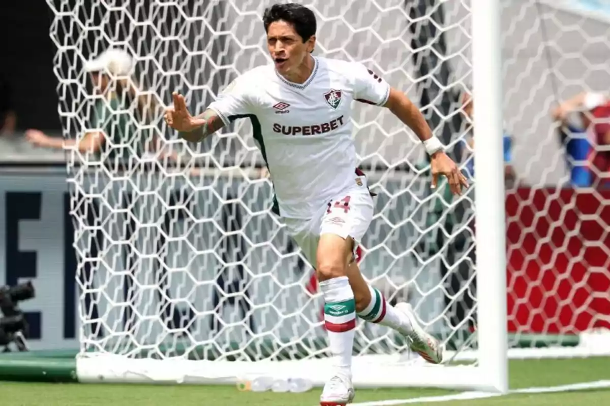 Soccer player celebrating a goal in front of the goal wearing Fluminense's white uniform