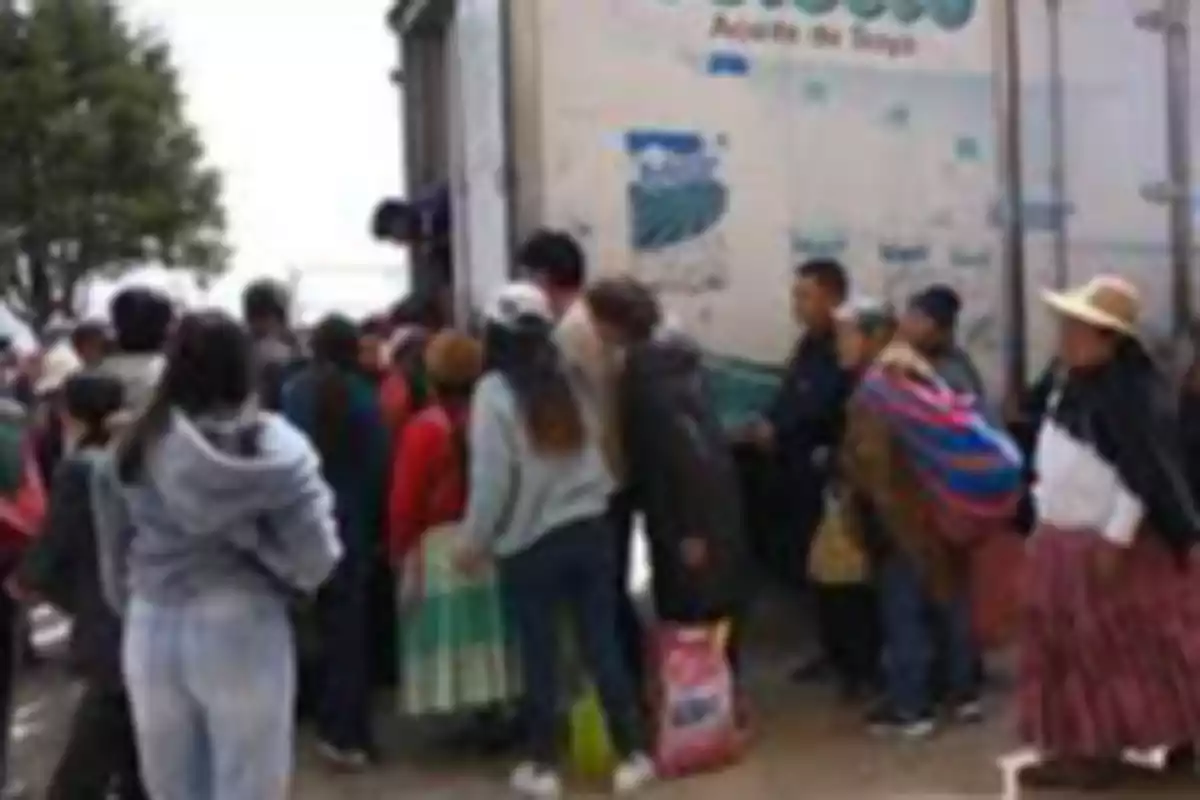 Personas haciendo fila junto a un camión en un entorno al aire libre