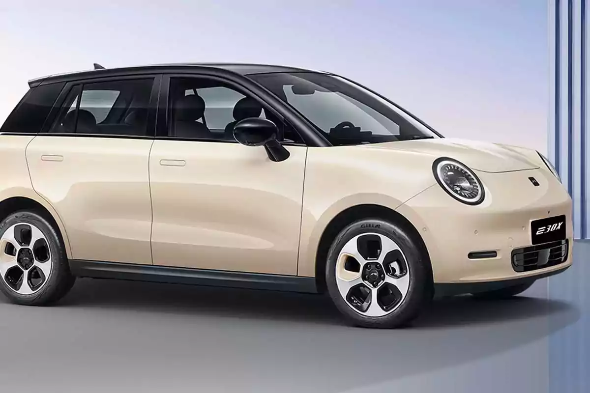 Auto compacto eléctrico color beige con techo negro y diseño moderno estacionado en un entorno minimalista