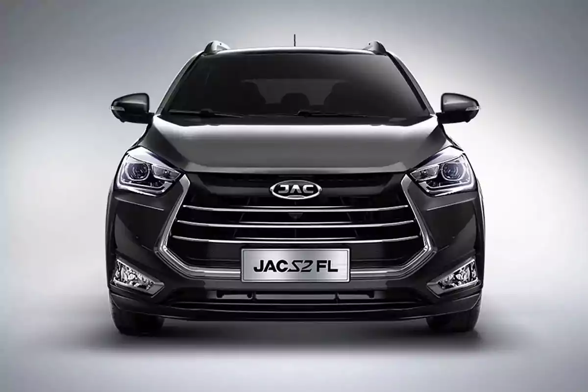 Vista frontal de una camioneta JAC S2 FL de color negro con faros encendidos y fondo gris claro Vista frontal de una camioneta JAC S2 FL de color negro con faros encendidos y fondo gris claro