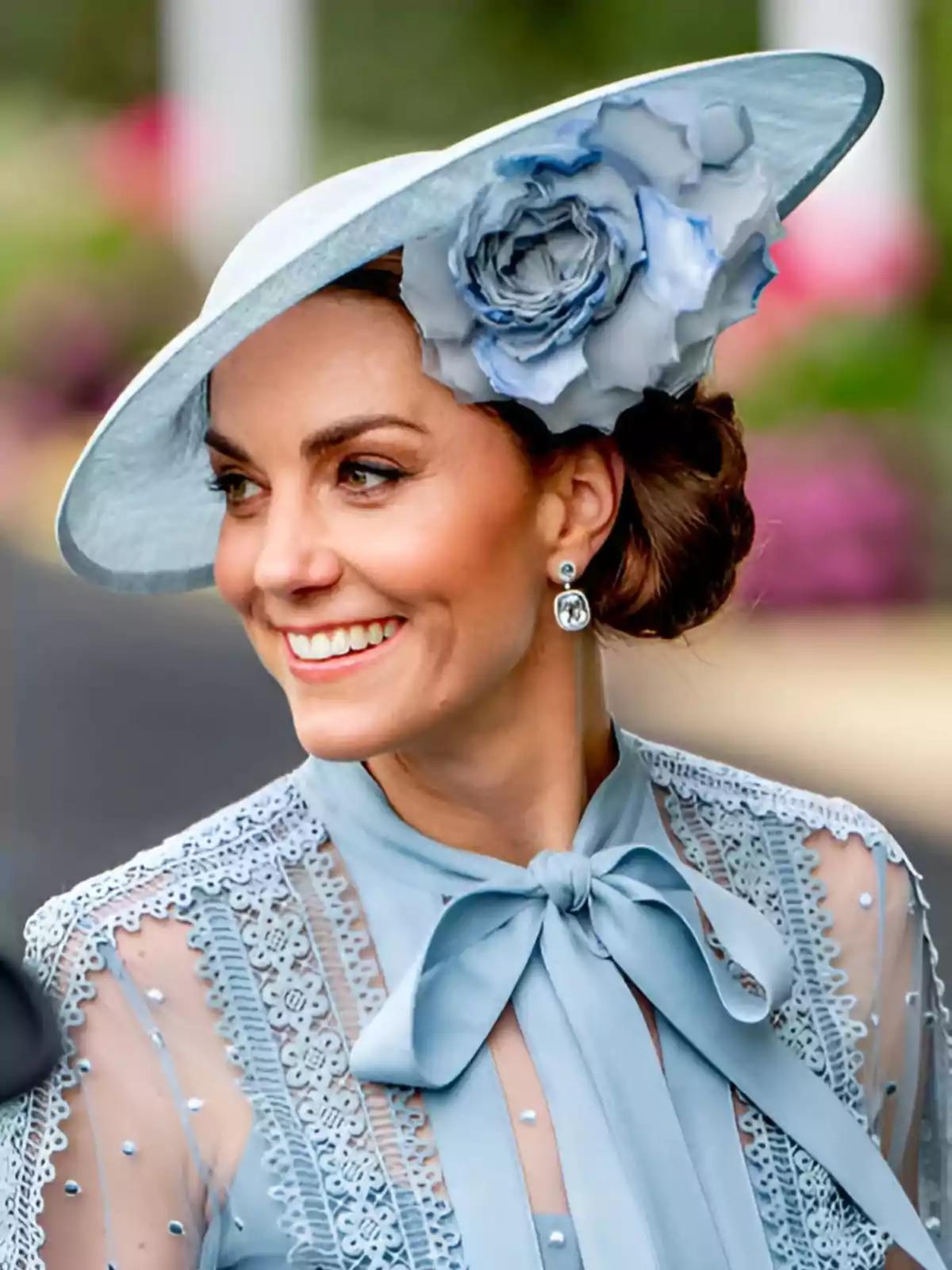 Mujer sonriente con sombrero azul claro adornado con una flor grande y blusa de encaje a juego Mujer sonriente con sombrero azul claro adornado con una flor grande y blusa de encaje a juego