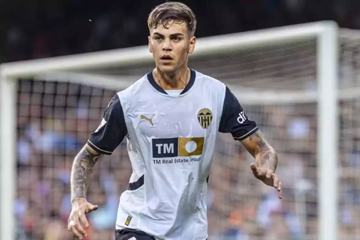 Soccer player wearing a Valencia CF uniform in the middle of a match in front of the goal Soccer player wearing a Valencia CF uniform in the middle of a match in front of the goal
