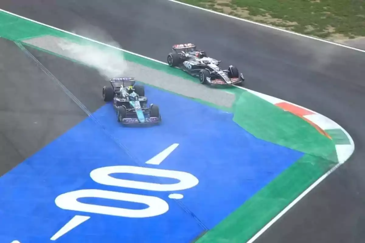 Two Formula 1 cars are racing through a corner; one of them goes off the track and kicks up dust over a blue area marked with the number 100. Two Formula 1 cars are racing through a corner; one of them goes off the track and kicks up dust over a blue area marked with the number 100.