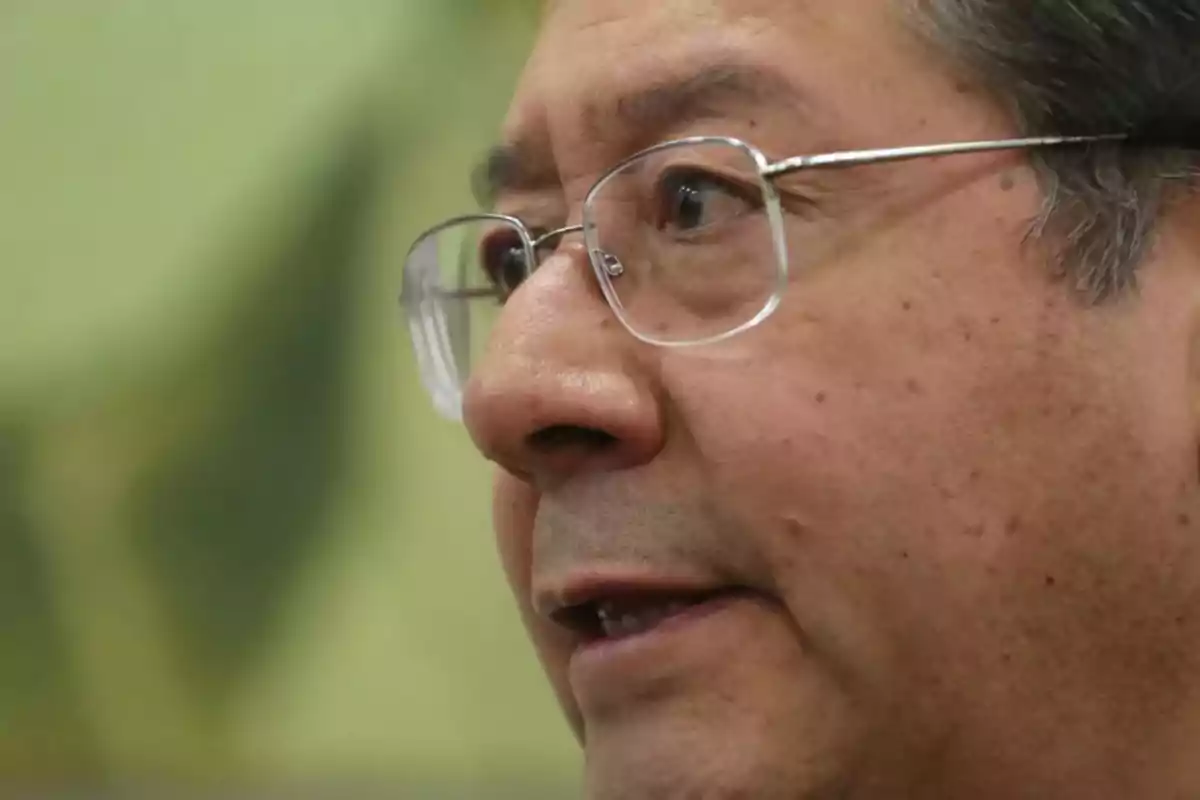 Primer plano de un hombre con gafas y cabello canoso mirando hacia la derecha Primer plano de un hombre con gafas y cabello canoso mirando hacia la derecha