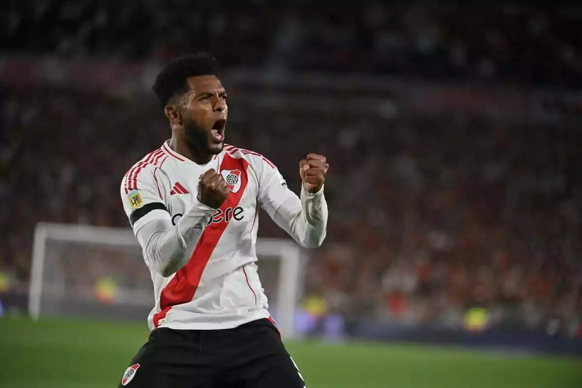 River Plate player celebrating a goal with clenched fists and an expression of euphoria in the stadium. River Plate player celebrating a goal with clenched fists and an expression of euphoria in the stadium.