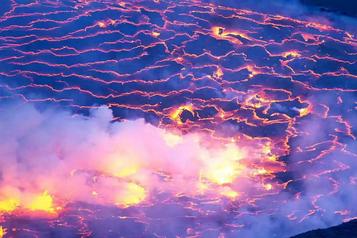 Lava incandescente fluyendo y emitiendo vapor en la superficie de un volcán