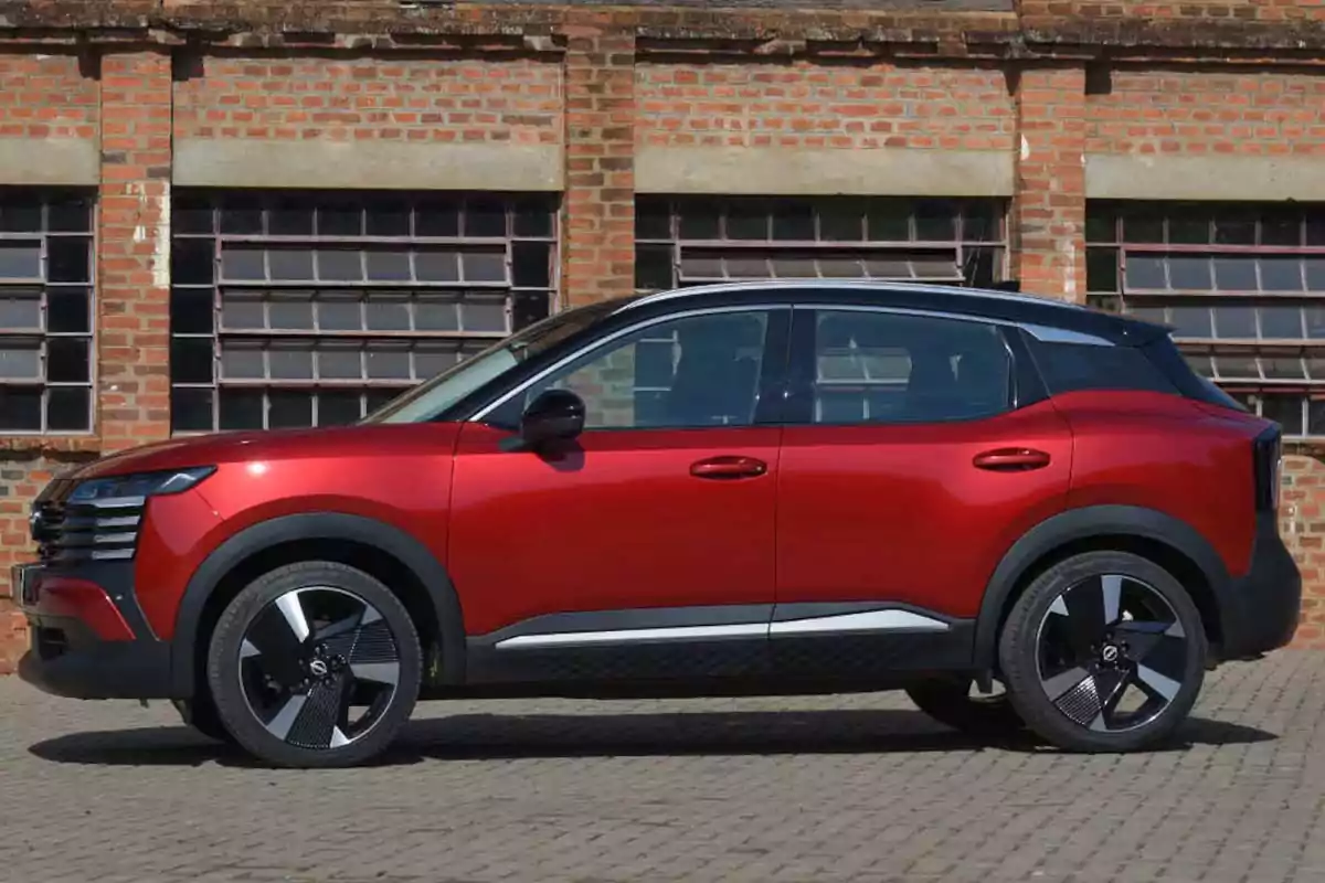 Red SUV parked in front of a brick wall with large windows Red SUV parked in front of a brick wall with large windows