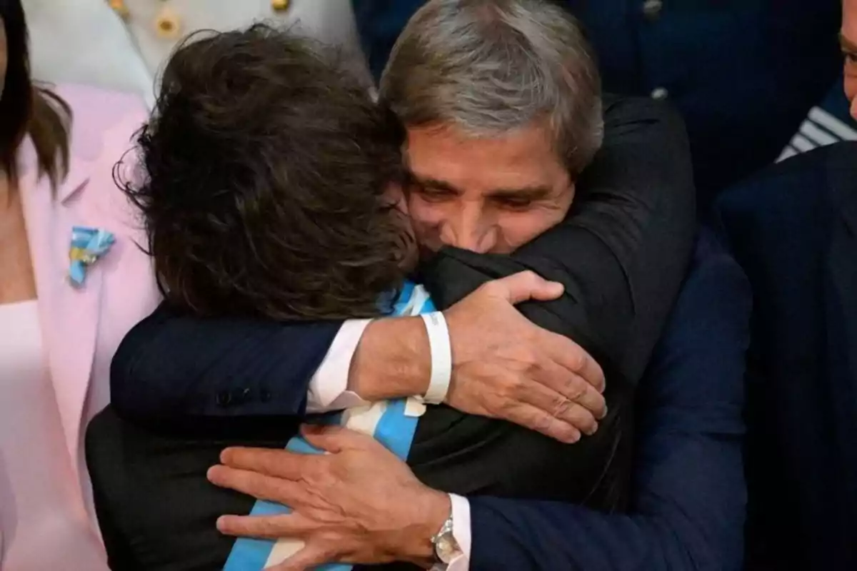 Dos hombres se abrazan con fuerza y emoción en un evento formal