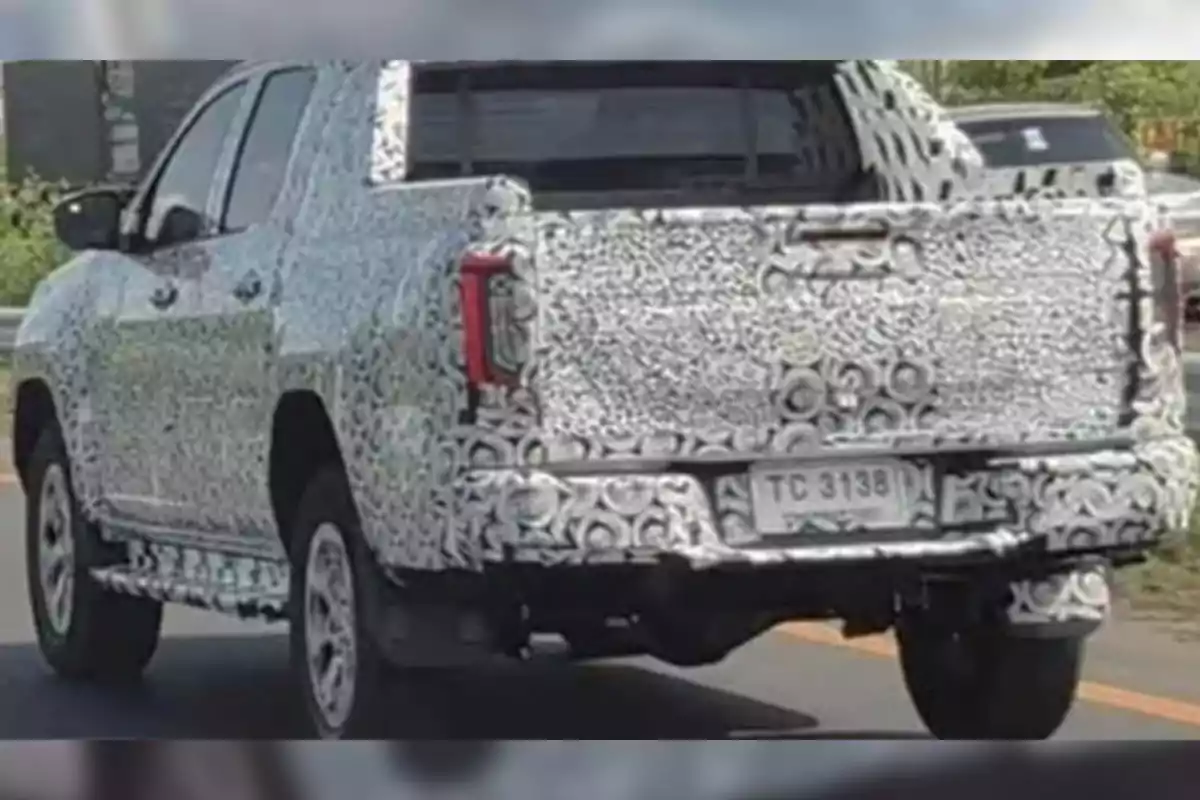 Camioneta cubierta con camuflaje de pruebas circulando por una carretera Camioneta cubierta con camuflaje de pruebas circulando por una carretera