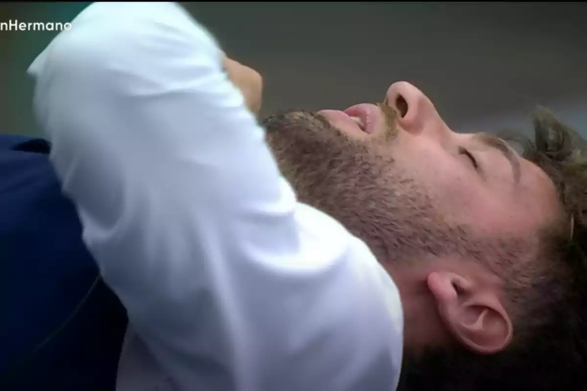 Man lying down with his eyes closed and an expression of tiredness or emotion