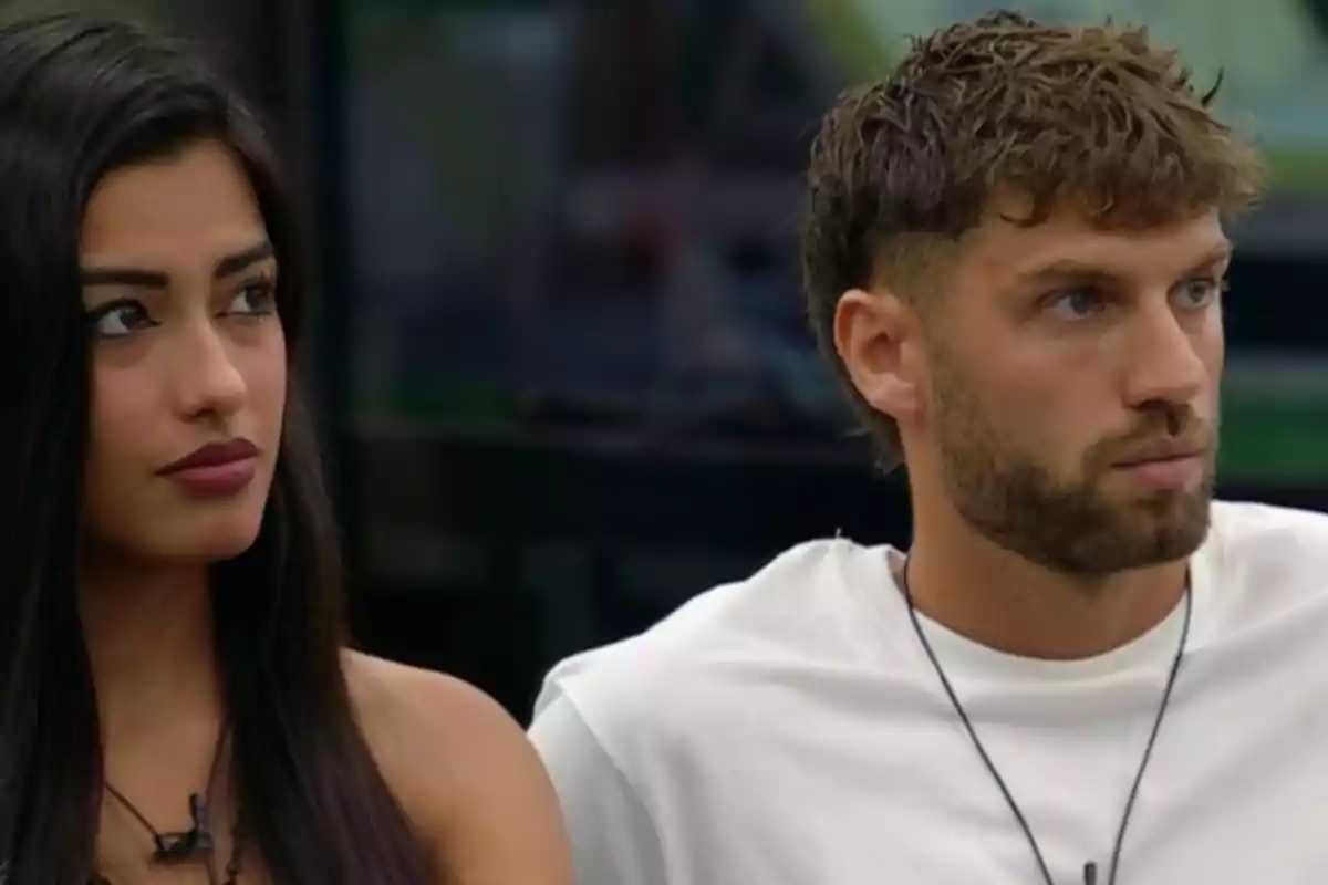 Two people sitting facing forward with serious expressions Two people sitting facing forward with serious expressions