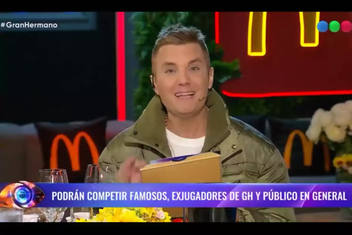 TV host speaking on a show with McDonald's-themed decor and a banner announcing the participation of celebrities, former GH contestants, and the general public TV host speaking on a show with McDonald's-themed decor and a banner announcing the participation of celebrities, former GH contestants, and the general public