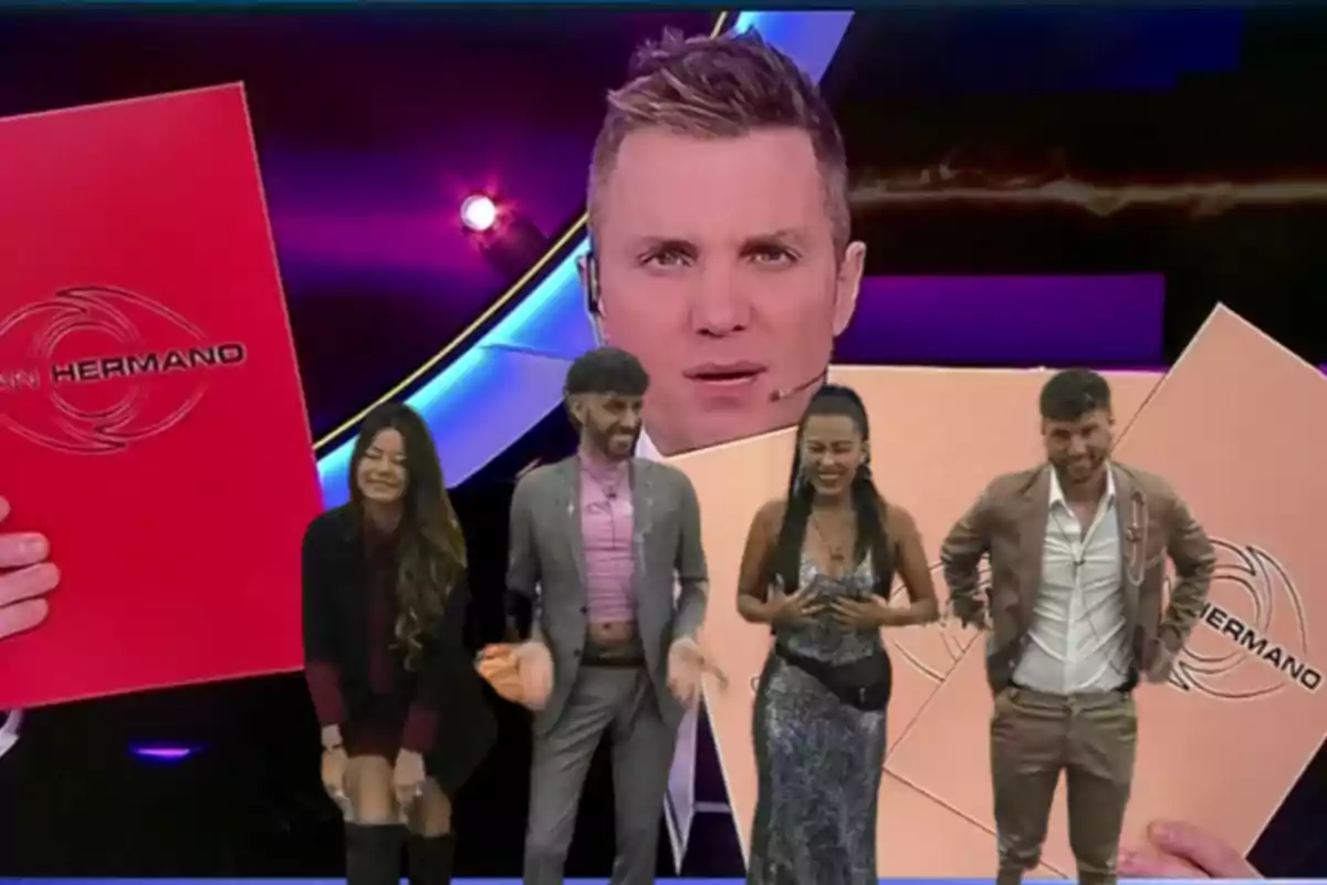 Four people smile on a television set with a colorful background and the image of a host behind them holding large red and beige folders with the logo of a show called Big Brother.
