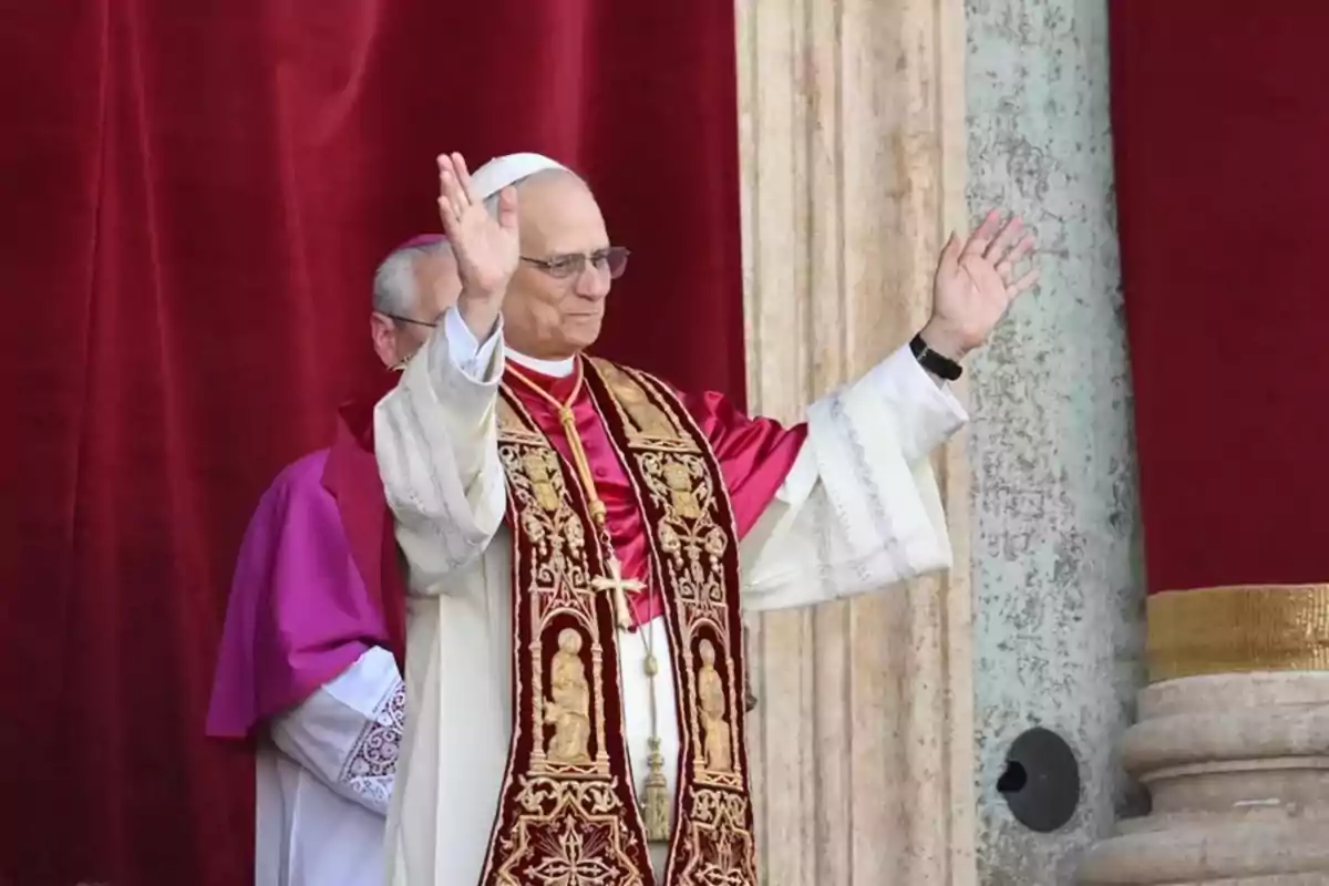 A man in papal attire raises both arms in front of a red curtain A man in papal attire raises both arms in front of a red curtain