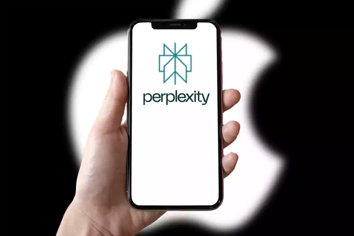 A hand holds a mobile phone displaying the Perplexity logo and word, with a blurred Apple logo in the background.
