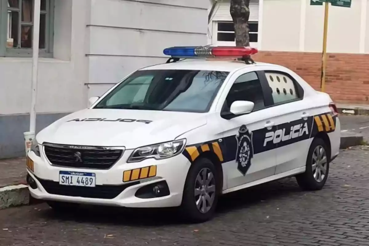 Uruguayan police patrol car parked on a street next to a building