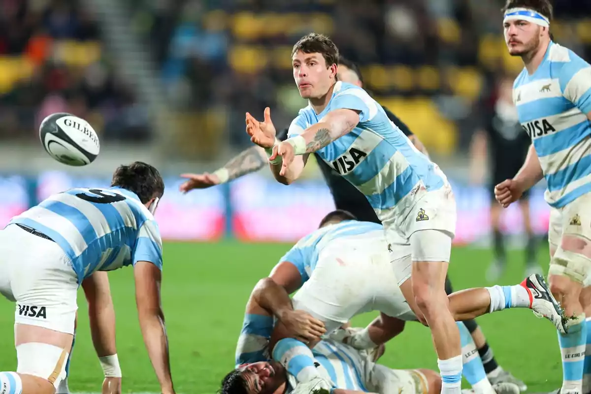 Argentinian rugby player passing the ball during a match while his teammates support him on the field
