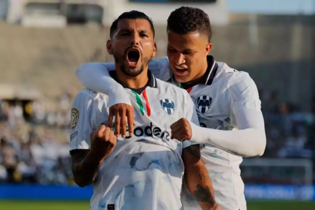 Dos futbolistas del equipo Monterrey celebran un gol con emoción en el campo de juego Dos futbolistas del equipo Monterrey celebran un gol con emoción en el campo de juego
